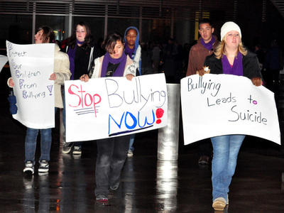 protestors carry anti-bullying signs
